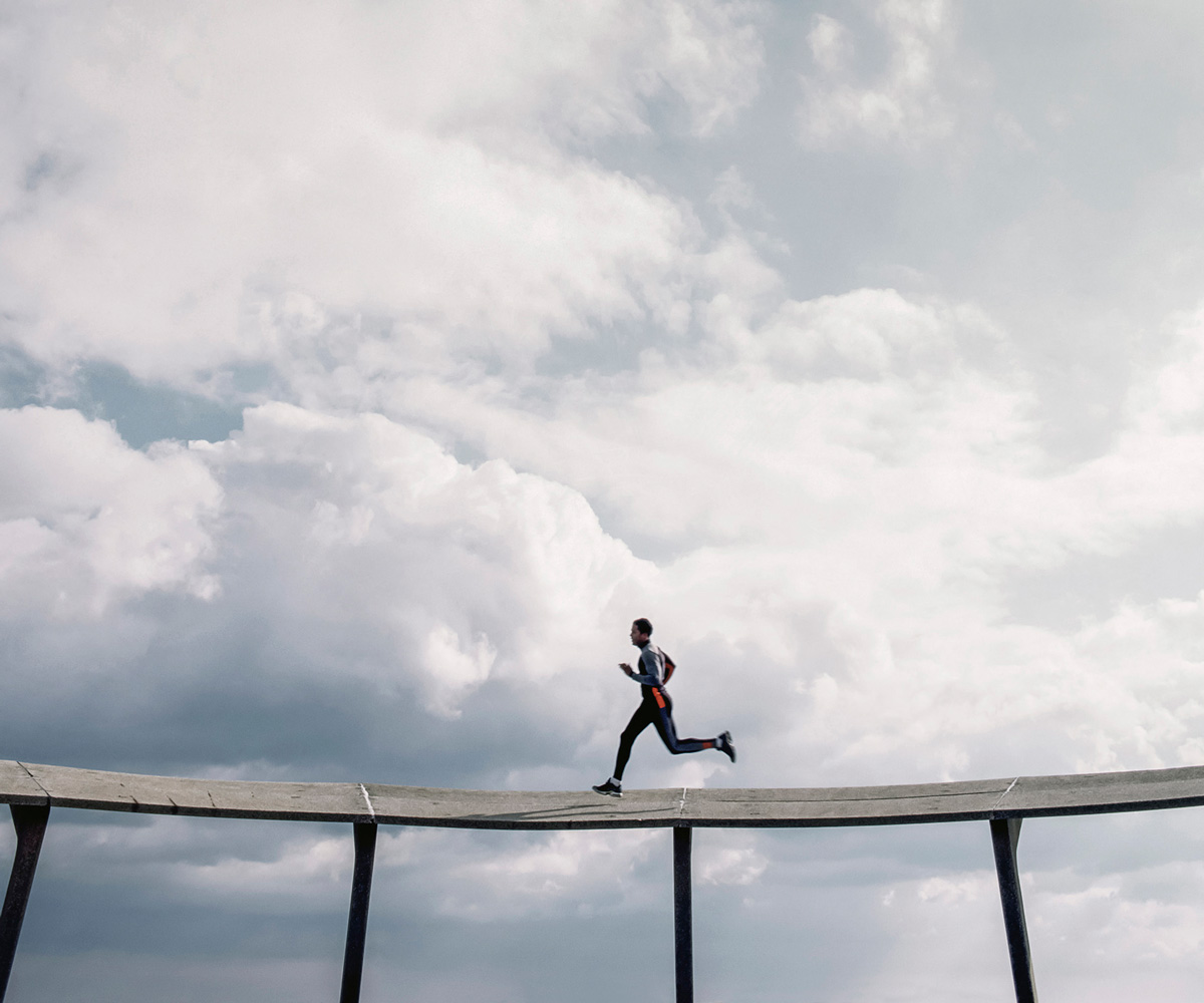 Athletic man running on sky bridge